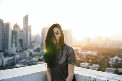 女人穿着灰色的t恤在屋顶上的日出
